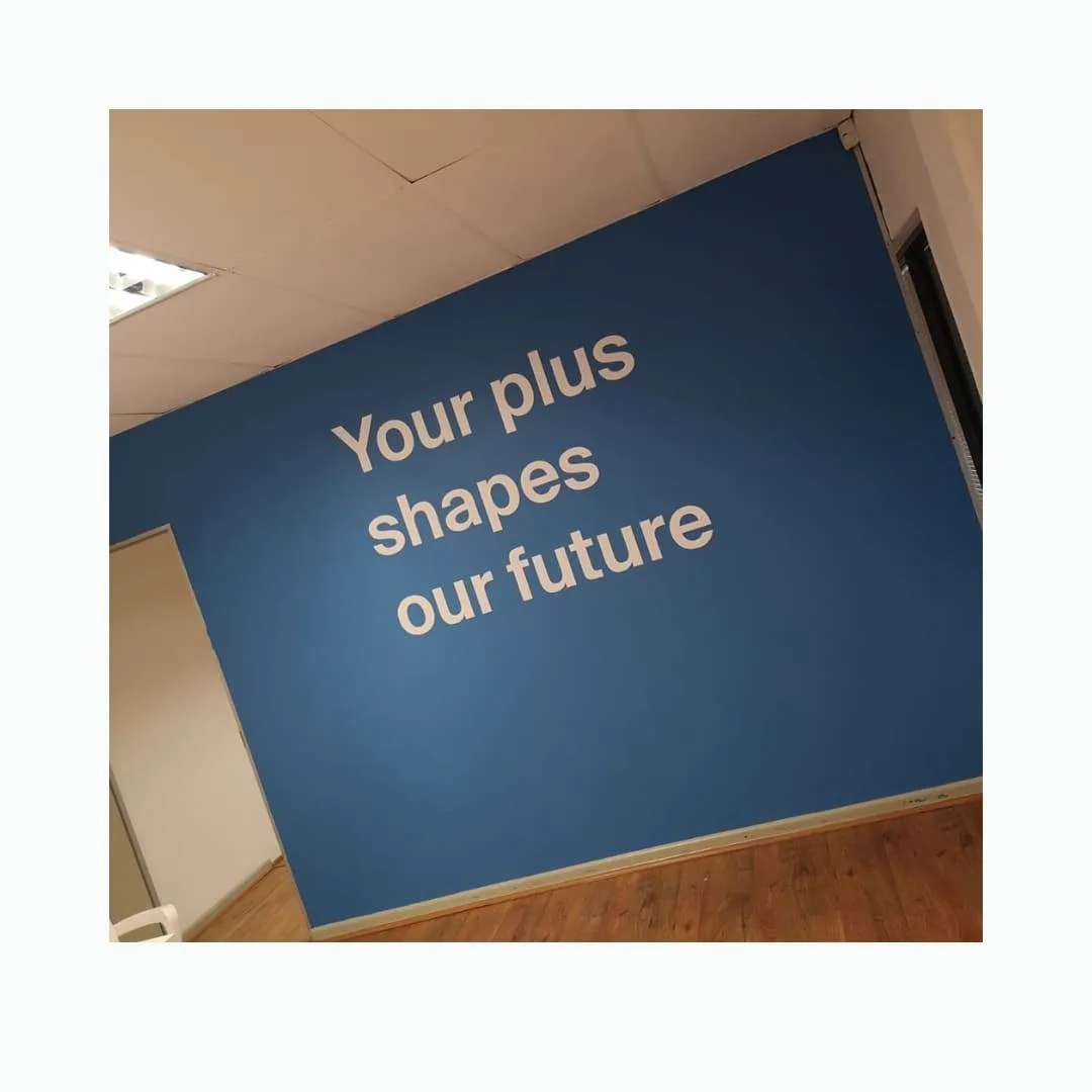 Cut vinyl wall lettering applied to a blue office feature wall
