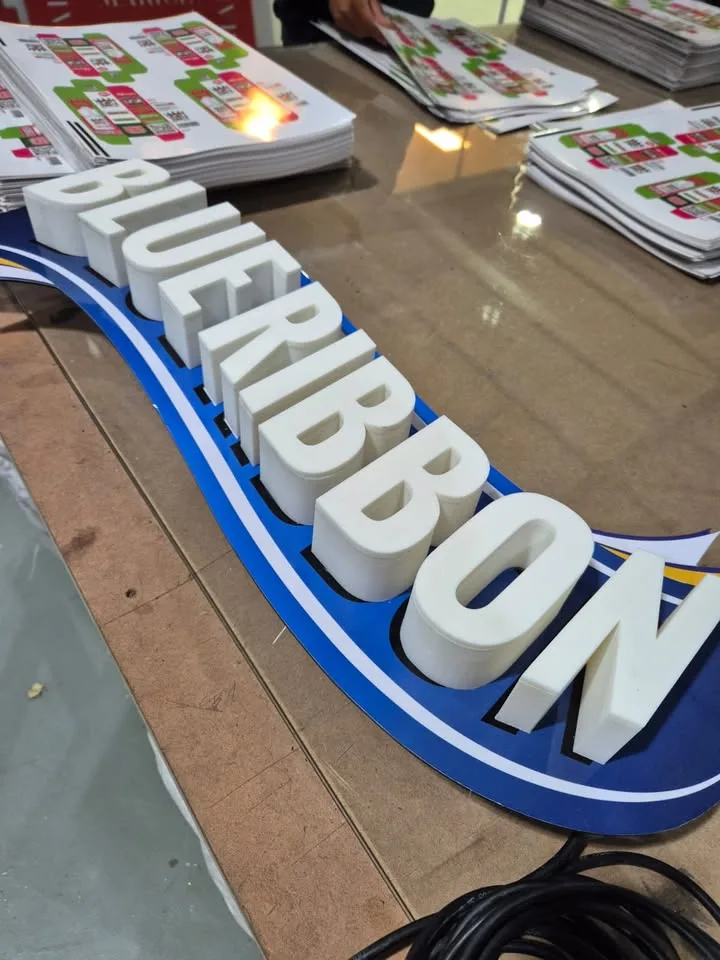 Built-up illuminated Blue Ribbon letters on the workshop floor